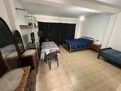 a room with two beds and a table in it at Monoambiente NONA in Villa Cura Brochero