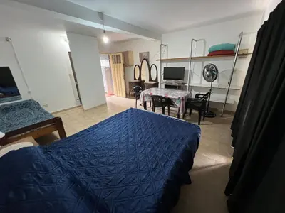 a bedroom with a blue bed and a table at Monoambiente NONA in Villa Cura Brochero