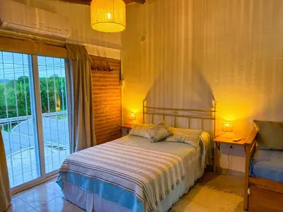 a bedroom with a bed and a large window at Clomplejo MUNAY con piscina y parking in Villa Cura Brochero