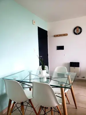 a dining room with a glass table and white chairs at Departamento en Barrio General Paz calle Güemes in Cordoba