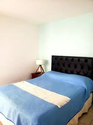 a bedroom with a blue bed with a black headboard at Departamento en Barrio General Paz calle Güemes in Cordoba