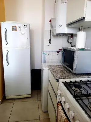 a kitchen with a white refrigerator and a microwave at Departamento en Barrio General Paz calle Güemes in Cordoba