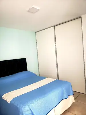 a bedroom with a blue bed with sliding glass doors at Departamento en Barrio General Paz calle Güemes in Cordoba