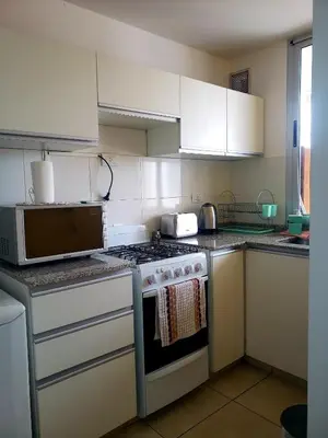 a kitchen with a stove and a microwave at Departamento en Barrio General Paz calle Güemes in Cordoba