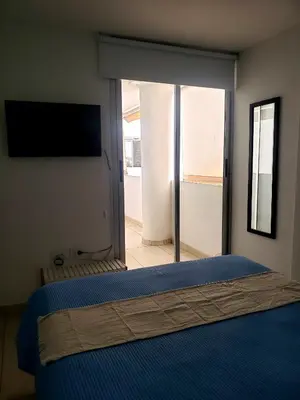 a bedroom with a large bed and a sliding glass door at Departamento en Barrio General Paz calle Güemes in Cordoba