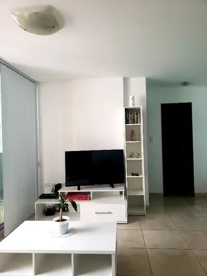 a living room with a tv and a white table at Departamento en Barrio General Paz calle Güemes in Cordoba