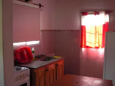 a kitchen with a sink and a red window at Brisa de los Molles in Los Molles