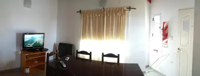 a living room with a table and a television at Brisa de los Molles in Los Molles