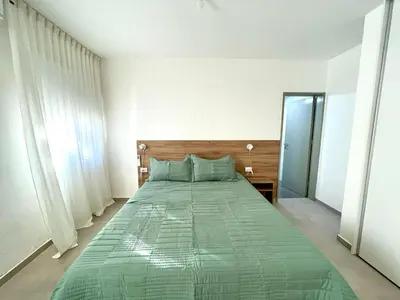 a bedroom with a bed with a green comforter at NueveSesenta Loft in Cordoba