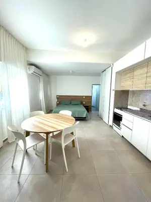 a kitchen and dining room with a table and a bed at NueveSesenta Loft in Cordoba