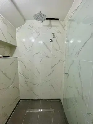 a bathroom with a shower with white marble walls at NueveSesenta Loft in Cordoba