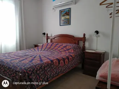 a bedroom with a bed with a colorful comforter at Cabaña Sombra Lunar en Cabañas Encuentro in Carpintería