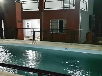a swimming pool in front of a building at Cabaña Sombra Lunar en Cabañas Encuentro in Carpintería