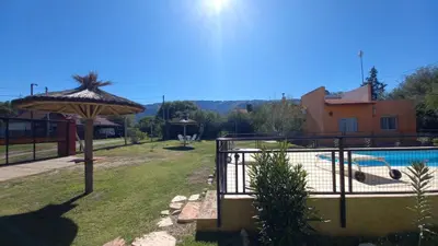 a patio with an umbrella next to a swimming pool at Cabaña Sombra Lunar en Cabañas Encuentro in Carpintería