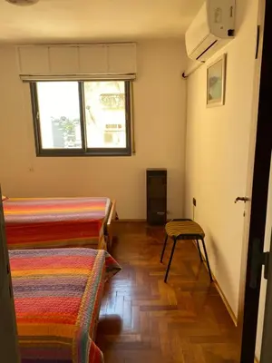 a room with two beds and a window at Departamento temporario Colon y Fragueiro in Cordoba