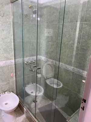 a bathroom with a glass shower with a toilet at Departamento temporario Colon y Fragueiro in Cordoba