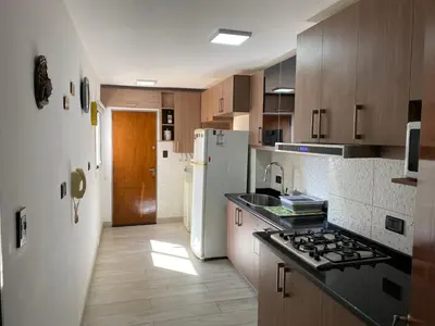 a kitchen with a sink and a white refrigerator at Departamento temporario Colon y Fragueiro in Cordoba