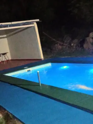 a large blue swimming pool at night at Karylago11 in San Roque