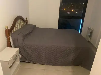 a bed with a brown bedspread in a bedroom at Departamento en Paseo Quatro in Villa Carlos Paz