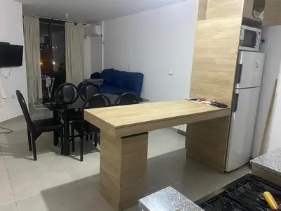 a kitchen and dining room with a table and a refrigerator at Departamento en Paseo Quatro in Villa Carlos Paz
