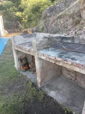 a stone bench with a fire under it at Karylago in Casa Bamba