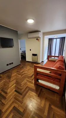 a room with a bed and a tv and wooden floors at Departamento -Buenos Aires- Pleno Nueva Cordoba By Apartcba in Cordoba