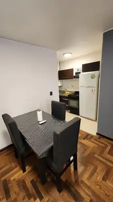 a dining room table with chairs and a kitchen at Departamento -Buenos Aires- Pleno Nueva Cordoba By Apartcba in Cordoba