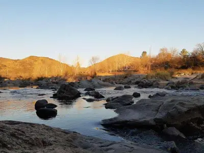 a river with some rocks and some water at Departamentos Luluara in Villa Carlos Paz