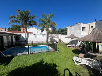 a backyard with a swimming pool and a house at Departamentos Luluara in Villa Carlos Paz