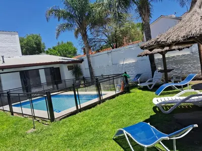 a backyard with a swimming pool and a house at Departamentos Luluara in Villa Carlos Paz