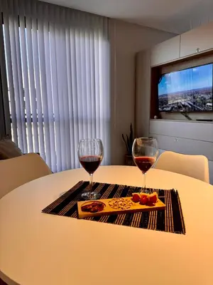 a table with two glasses of wine and food on it at Bahía 108 Apart Premium in Villa Carlos Paz