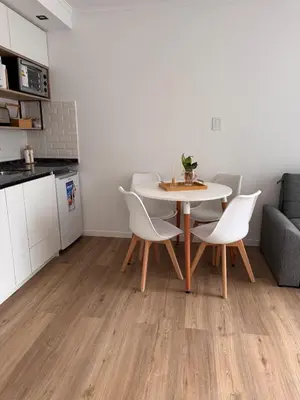 a kitchen and a table and chairs in a room at Bahía 108 Apart Premium in Villa Carlos Paz