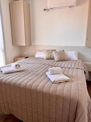 a bedroom with a large bed with towels on it at Bahía 108 Apart Premium in Villa Carlos Paz