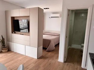 a bedroom with a bed and a tv in a cabinet at Bahía 108 Apart Premium in Villa Carlos Paz