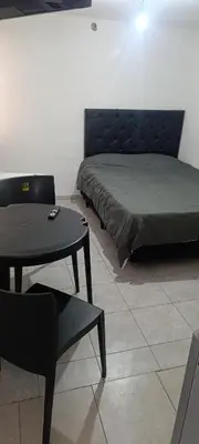a bed in a room with a table and a couch at Celeste departamento in Cordoba