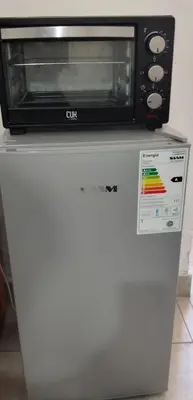 a microwave sitting on top of a white refrigerator at Celeste departamento in Cordoba