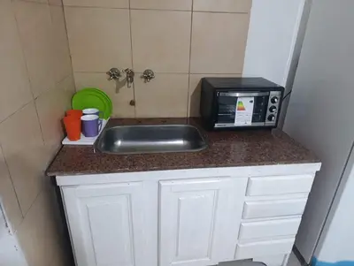 a kitchen counter with a sink and a microwave at Celeste departamento in Cordoba