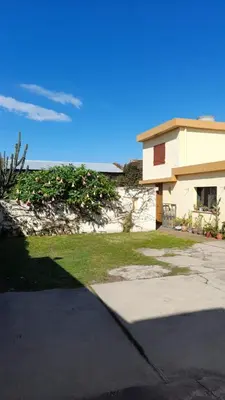 a house with a sidewalk next to a building at Las Crasas in Alta Gracia