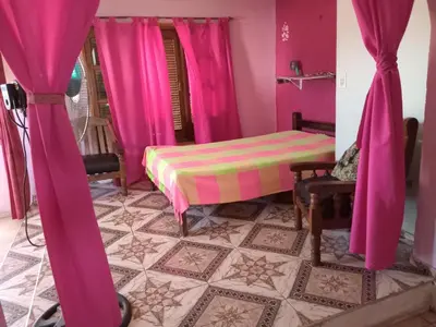 a bedroom with pink curtains and a bed in a room at Sol y rio in Villa Carlos Paz