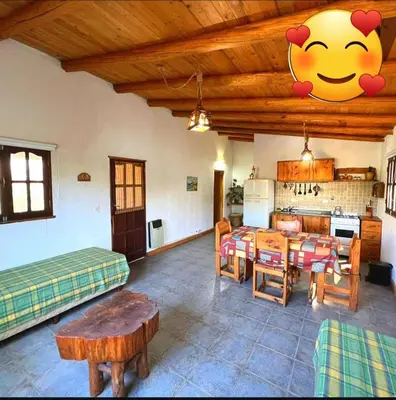 a living room with a table and a kitchen at das gelbe haus in Los Reartes