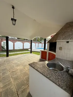 a kitchen with a sink and a patio at Chalet Pino azul in Villa Carlos Paz