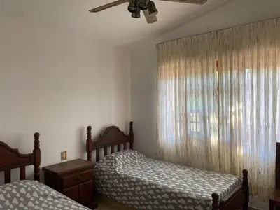 a bedroom with two twin beds and a window at Chalet Pino azul in Villa Carlos Paz