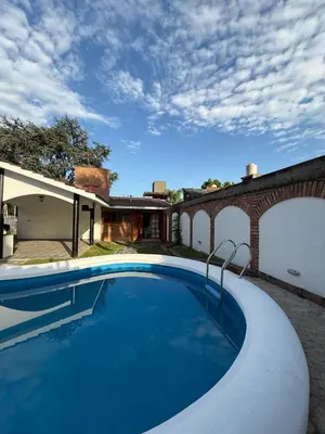 a swimming pool in the backyard of a house at Chalet Pino azul in Villa Carlos Paz