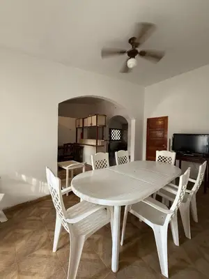a white dining table and chairs in a room at Chalet Pino azul in Villa Carlos Paz