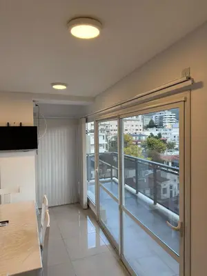 a room with a large glass door with a balcony at Edificio Leonardo Villa Carlos Paz in Villa Carlos Paz