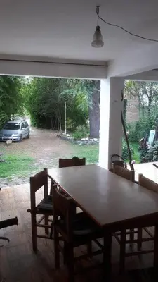 a wooden table and chairs in a living room at Casa en el Río in Alpa Corral