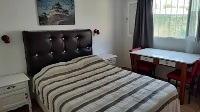 a bedroom with a bed and a desk and a window at Departamento con kitchenet con entrada independiente in Cordoba