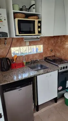 a kitchen with a counter with a sink and a microwave at Departamento con kitchenet con entrada independiente in Cordoba