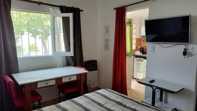 a small room with a bed and a desk and a window at Departamento con kitchenet con entrada independiente in Cordoba