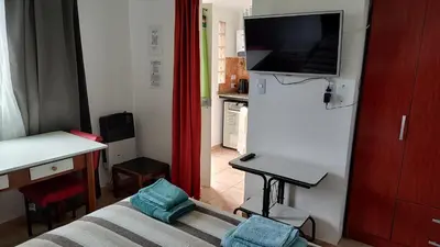 a small living room with a bed and a television at Departamento con kitchenet con entrada independiente in Cordoba